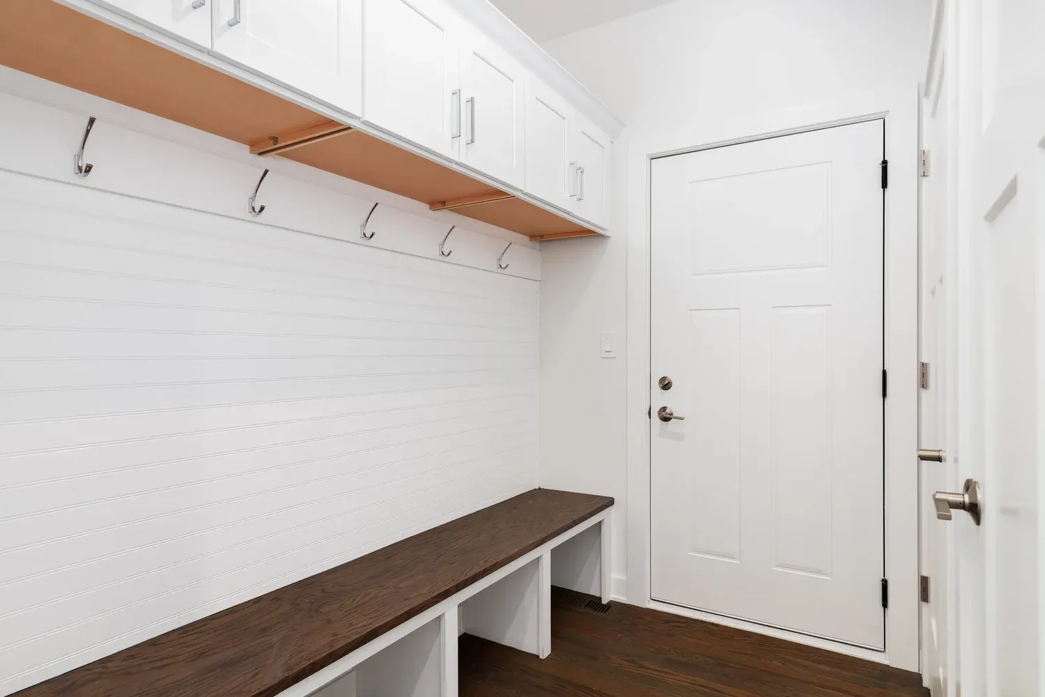 Custom mudroom closet with built-in bench, hooks and cabinets in a Wisconsin home