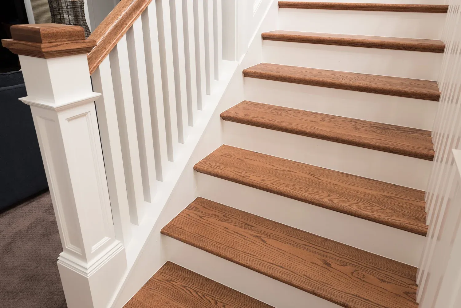 Hardwood stair treads, white risers and handrail installed by a Wisconsin carpenter